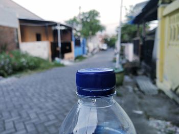 Close-up of water bottle on street in city