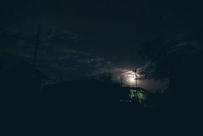 Low angle view of silhouette trees against sky at night