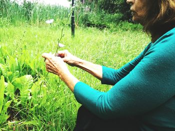 Low section of woman relaxing on grassy field