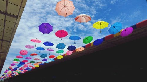 Low angle view of multi colored balloons against sky