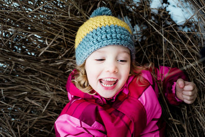 Close up of young girl playing on the ground outside in the snow