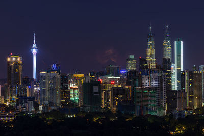 Illuminated buildings in city against sky at night