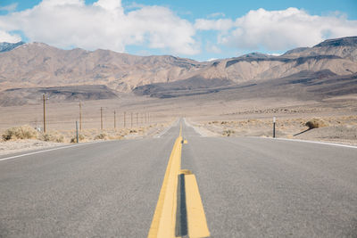 Empty road in desert against sky