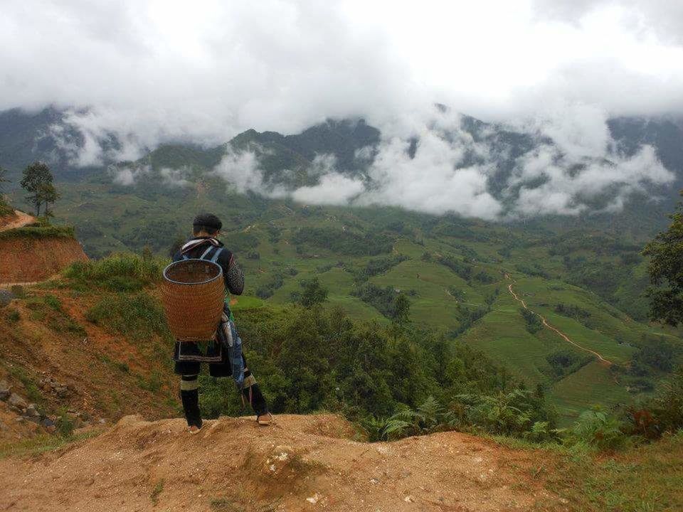 REAR VIEW OF MAN STANDING ON LANDSCAPE AGAINST MOUNTAIN RANGE