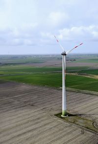 Windmill on field against sky
