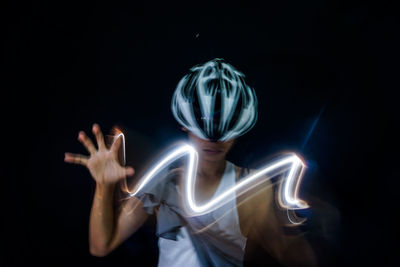 Midsection of person with light painting against black background