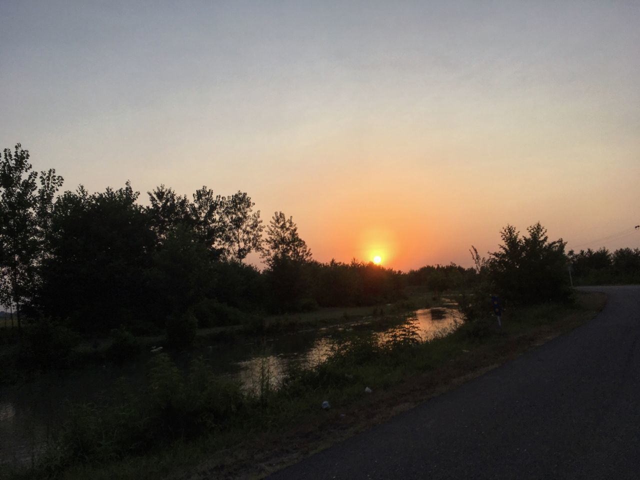 sunset, tree, nature, sun, orange color, scenics, no people, beauty in nature, tranquil scene, outdoors, tranquility, sky, sunlight, silhouette, landscape, road, clear sky, day