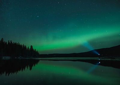 Scenic aurora view of lake against star field at night