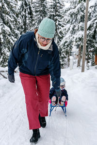 Mother and daughter playing on snow