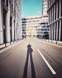 Shadow of man on street amidst buildings