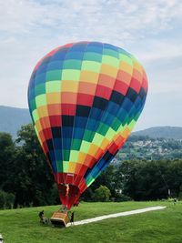 Multi colored hot air balloons on field against sky