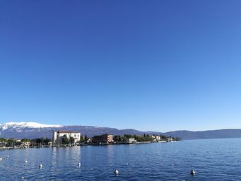 Scenic view of lake against clear blue sky