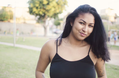 Portrait of beautiful woman standing against blurred background