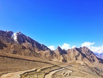 Scenic view of mountains against blue sky