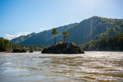 Scenic view of sea and mountains against clear sky