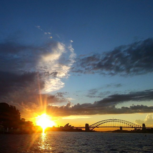 sunset, sun, water, sky, waterfront, cloud - sky, sunbeam, built structure, silhouette, sea, architecture, scenics, sunlight, beauty in nature, nature, tranquility, tranquil scene, connection, cloud, river