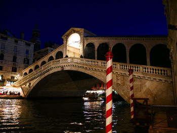 Arch bridge over river at night