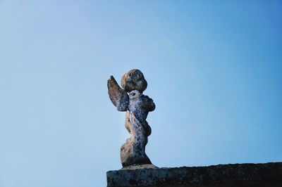 Low angle view of statue against clear blue sky