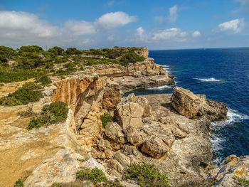 Scenic view of rock formation in sea against sky