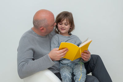 Full length of a boy sitting on book