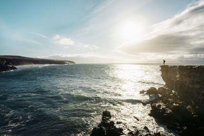 Spain, canary islands, fuerteventura, la pared, man standing on a cliff at sunset