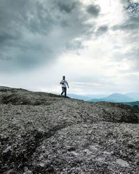 Man walking on mountain against sky