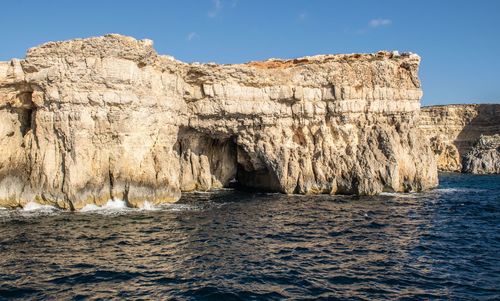 Scenic view of rocks in sea against sky