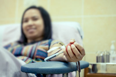 Smiling mid adult woman holding stress ball on hospital bed