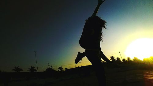 Low angle view of silhouette woman against sky during sunset