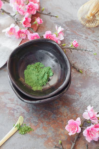 High angle view of green matcha tea in bowl amidst flowers