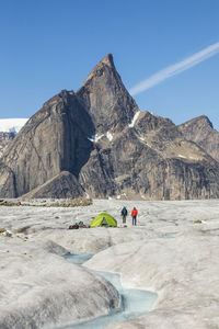 People on mountain range against clear sky