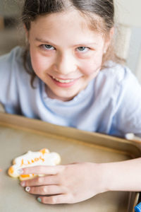 Close-up of cute girl eating food at home