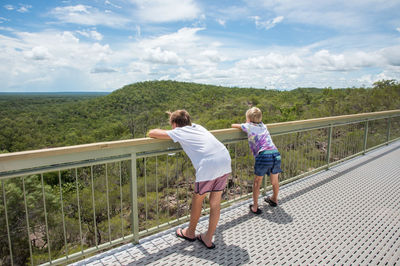 Rear view of women on railing against sky