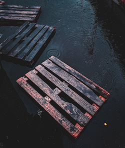 High angle view of empty bench by lake