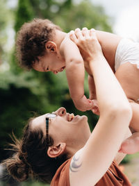 Smiling mother with son playing outdoors