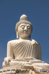 Low angle view of statue against temple against clear blue sky