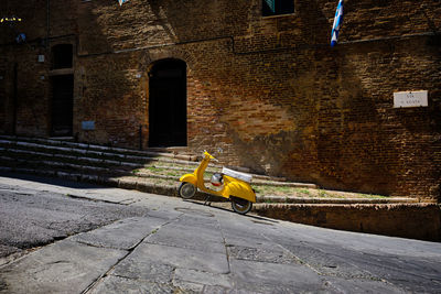 Yellow umbrella on footpath against building