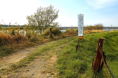 Wooden post on field against sky