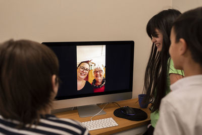 Children talking via vide chat with grandmother