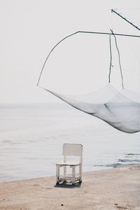 Lifeguard chair on beach against clear sky