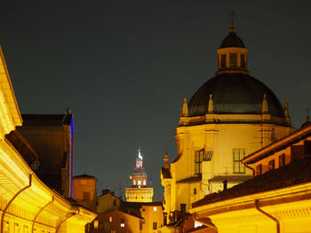 Low angle view of illuminated buildings against sky at night