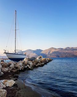 Sailboats in sea against clear blue sky