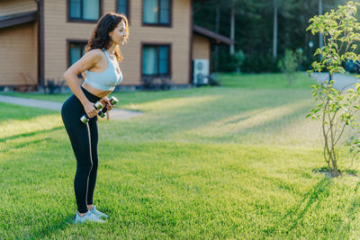 Full length of woman exercising at yard