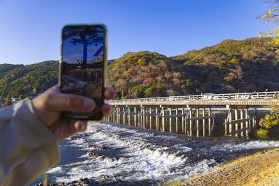 Low section of man photographing against sky