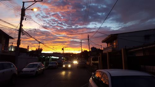 Cars on road against dramatic sky