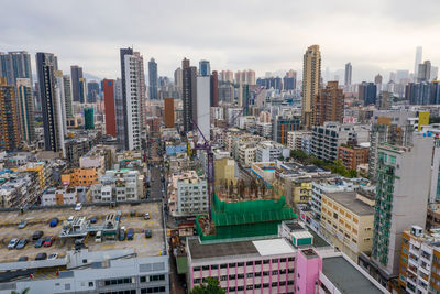 Aerial view of buildings in city against sky