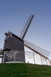 Low angle view of windmill on field against clear sky