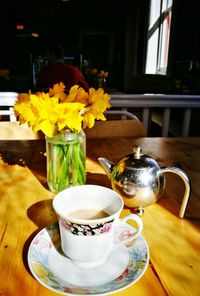 Tea cup and teapot on table in restaurant