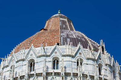 Detail of the cupola of the pisa baptistery of st. john against a beautiful blue sky