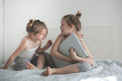 Girls are funny crazy kids argue over the laptop, the concept of childhood and gadgets, life style